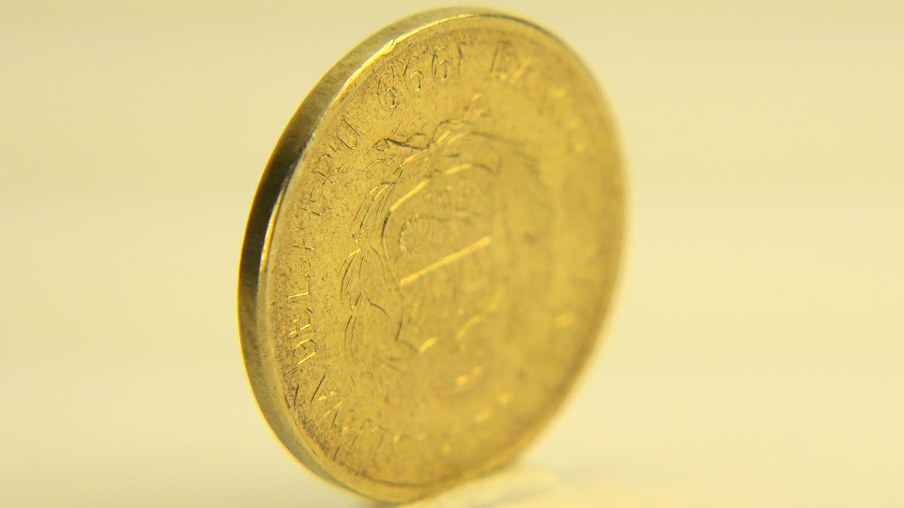 Close view of a golden coin tilted toward the camera