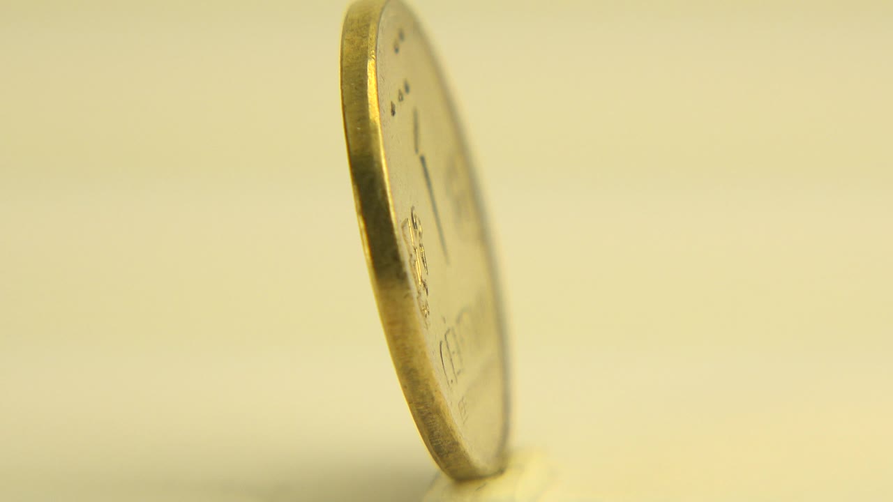 Coin standing at a slight angle with its face partly visible.