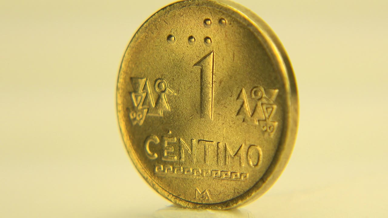 Gold-toned one centimo coin standing upright on a reflective surface.