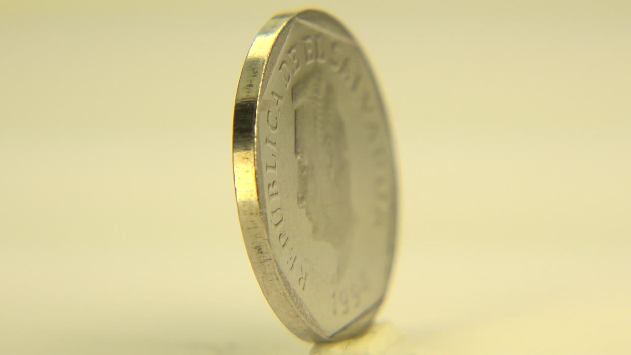 Coin turned partly toward camera with rim lettering faintly visible.