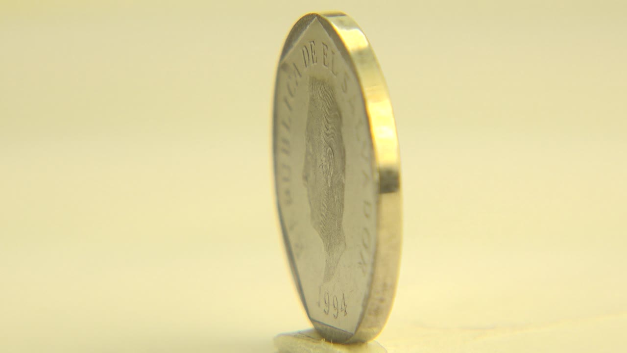 Coin turned partly sideways on a pale surface