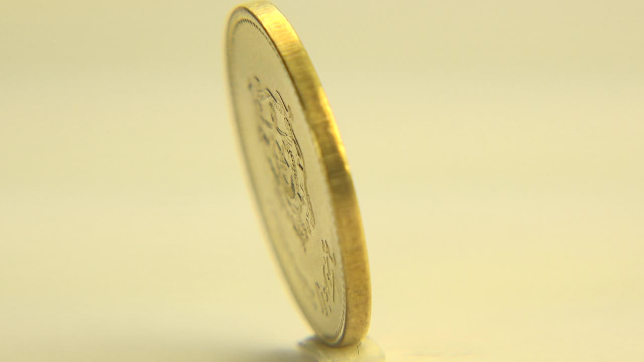 Thin edge of a spinning coin on a flat surface
