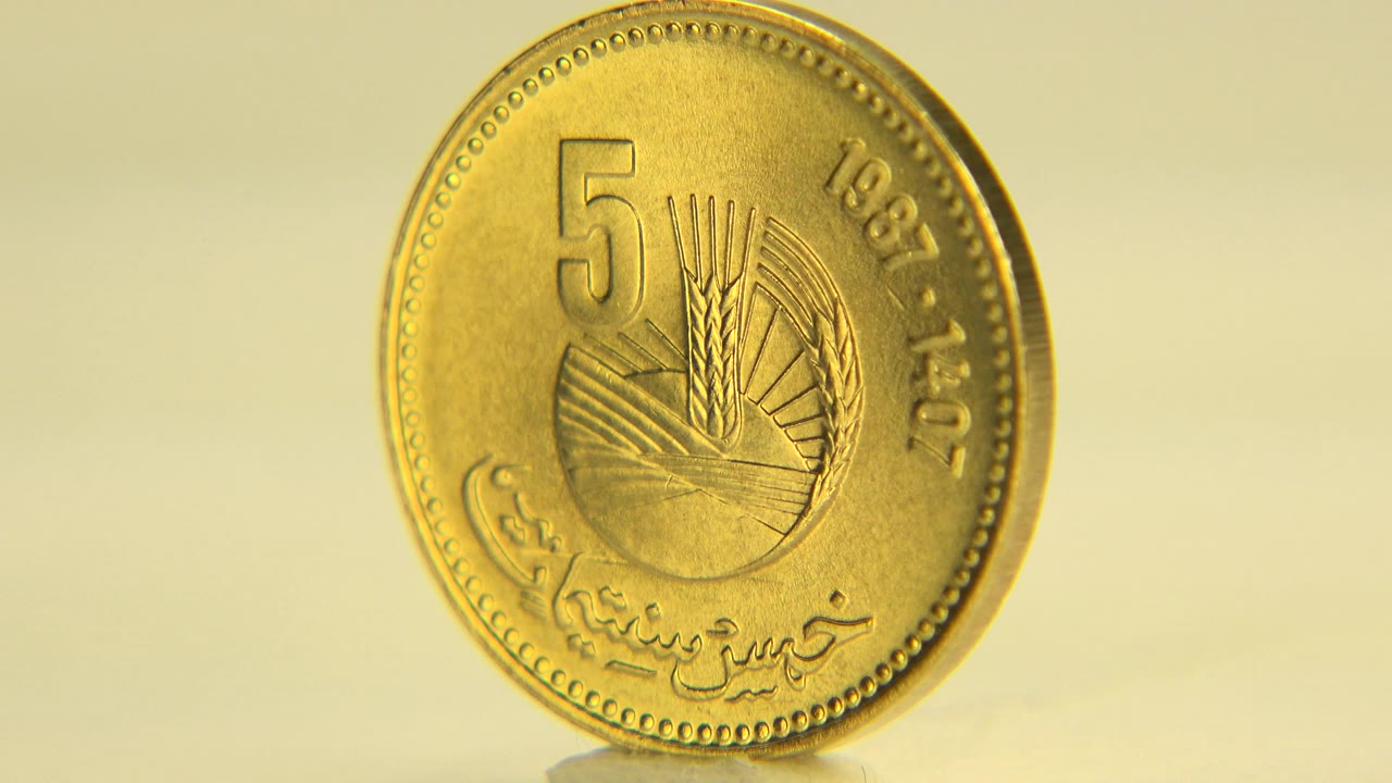 Gold-colored coin angled slightly while standing on a table