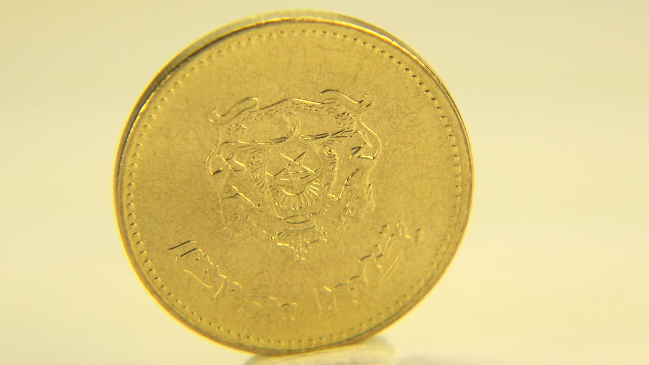 Gold coin face centered under yellow-white light