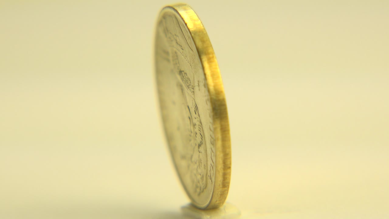 Gold-toned coin spinning on its edge