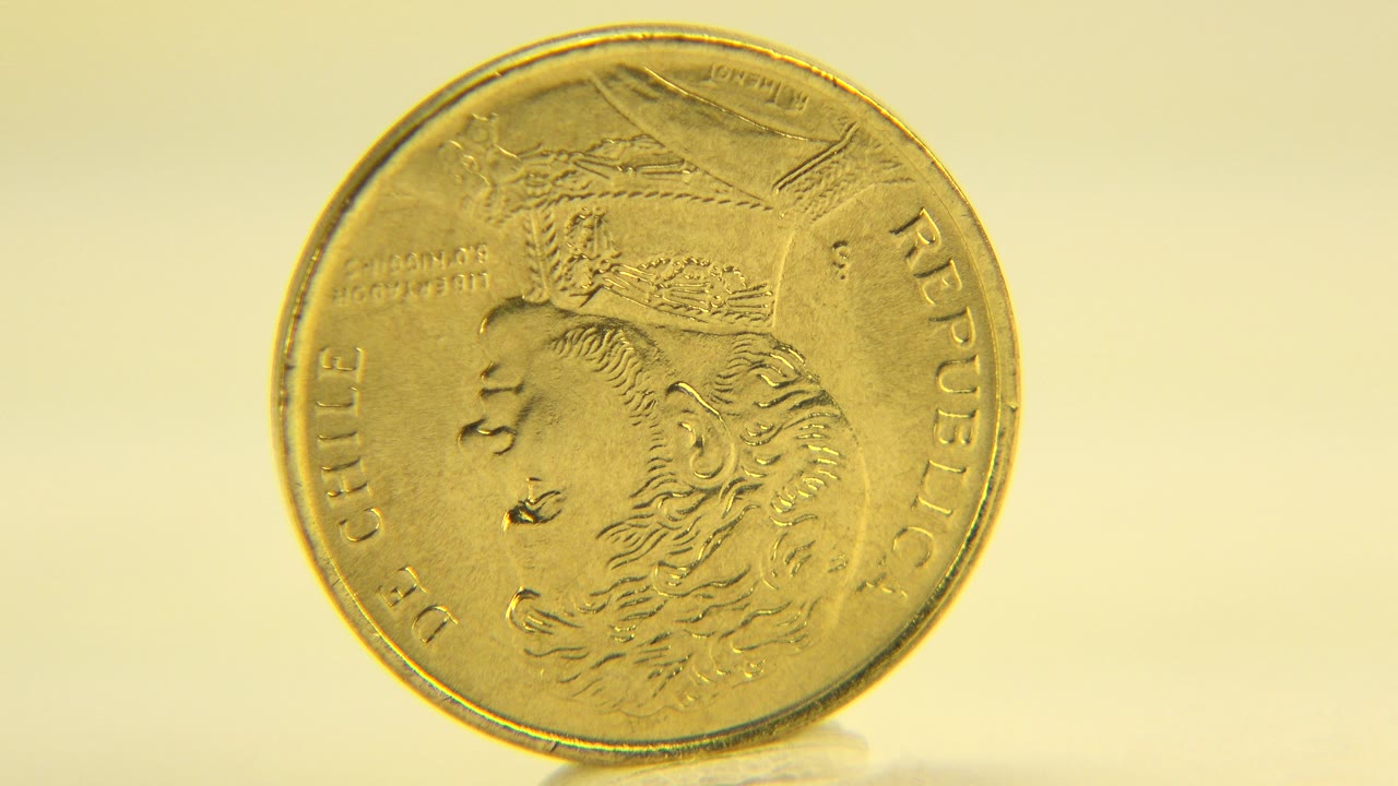 The coin remains upright and nearly front-facing on the pale tabletop in Westminster, Colorado, with the embossed profile still readable and no visible people.
