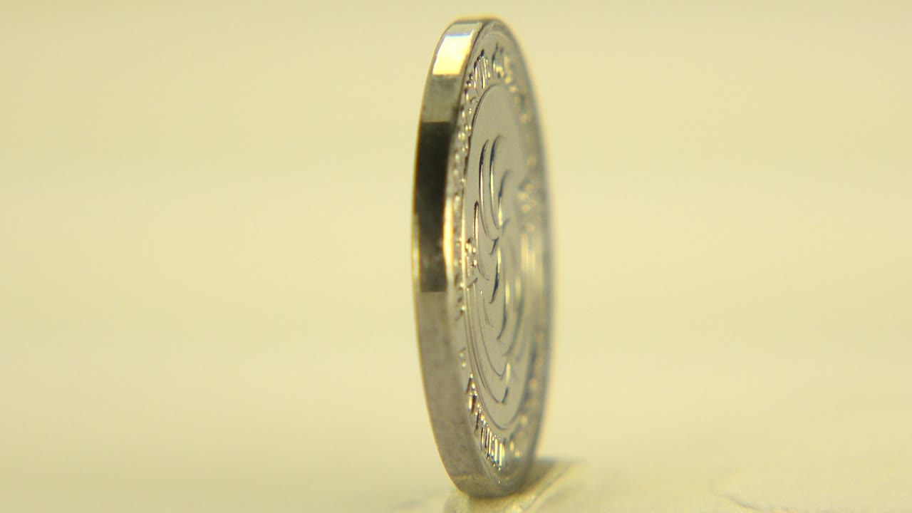 A silver Republic of Georgia coin stands nearly edge-on on a pale surface in Westminster, Colorado, with warm light and no visible people.