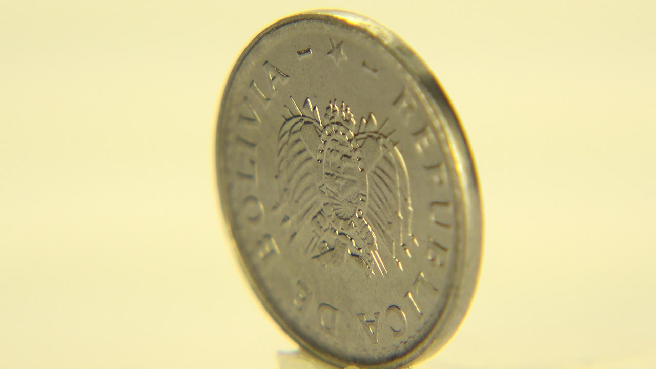 Coin angled to the side with crest side partly visible.