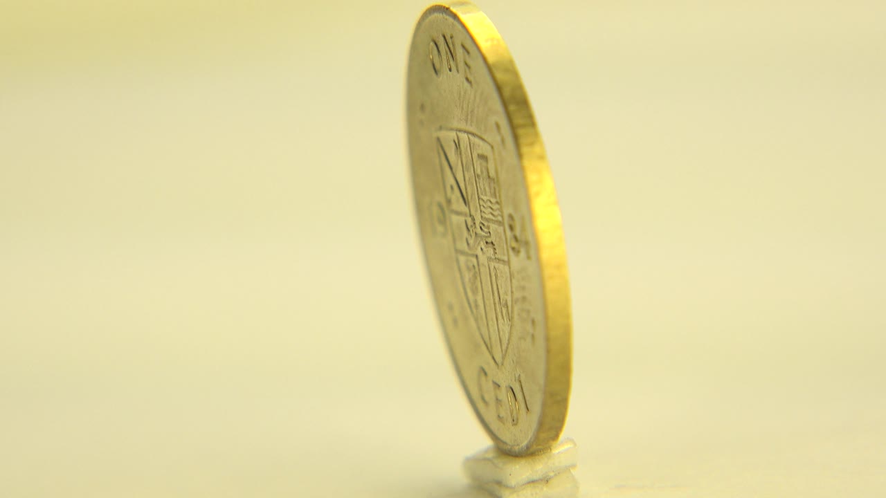 Thin edge of a gold coin standing upright