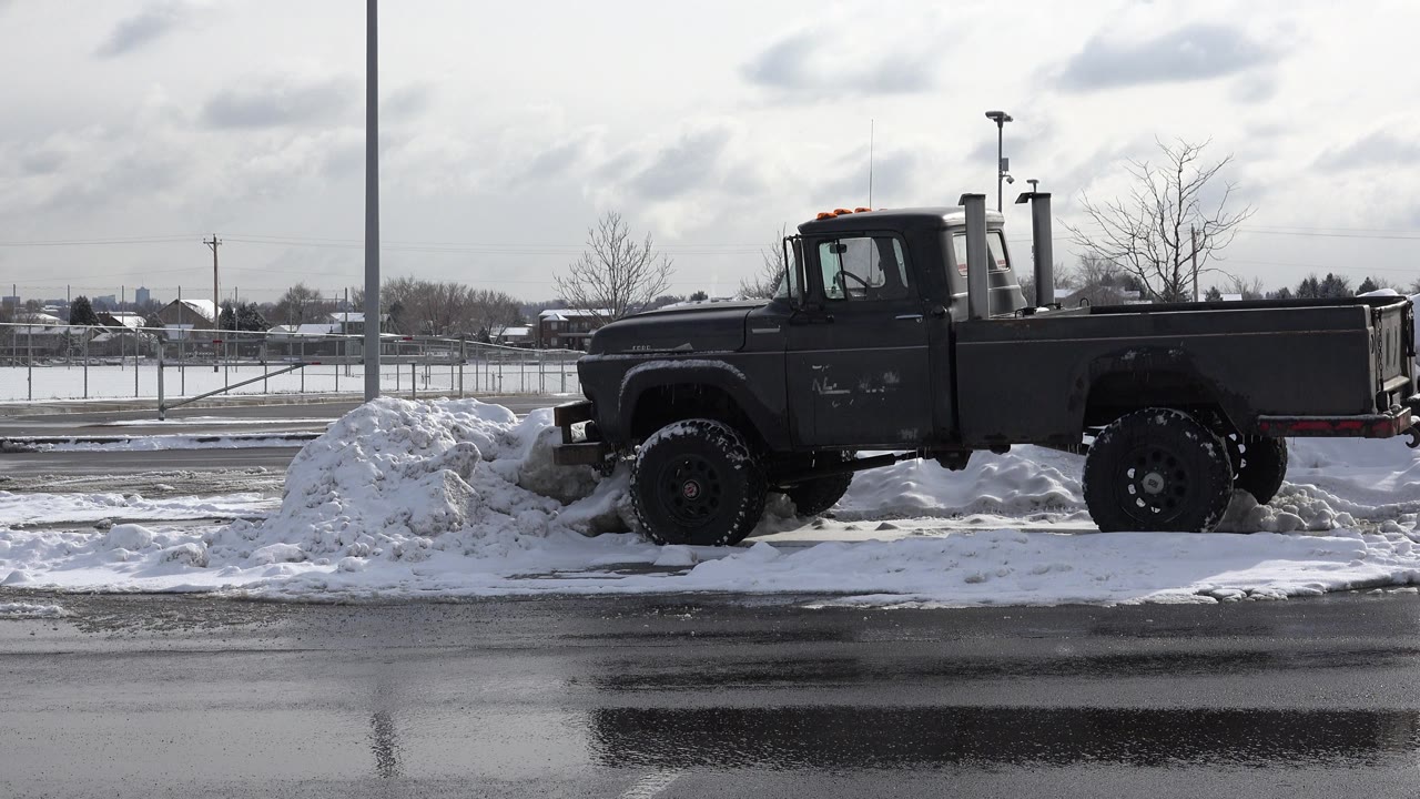The truck remains centered in profile in the Westminster, Colorado winter lot, with a snow mound near the front bumper and no visible people.