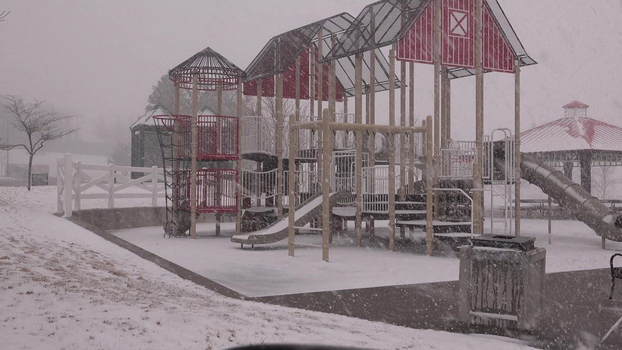Red playground towers and snow-covered park path