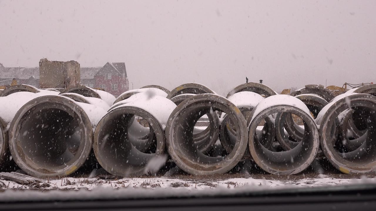 A slightly later view shows the concrete tubing covered with fresh snow as flakes pass in front of the lens at the Westminster, Colorado site, with no visible people.