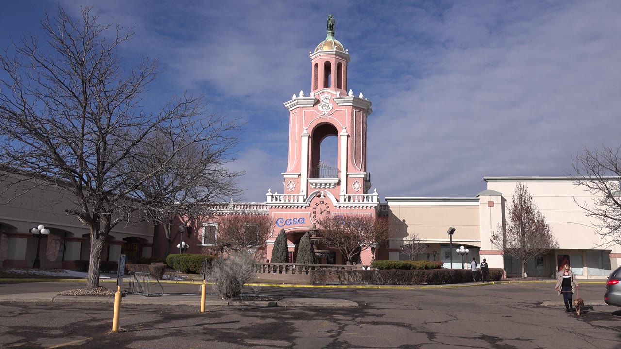 Large pink building tower with a car edge at the right side.