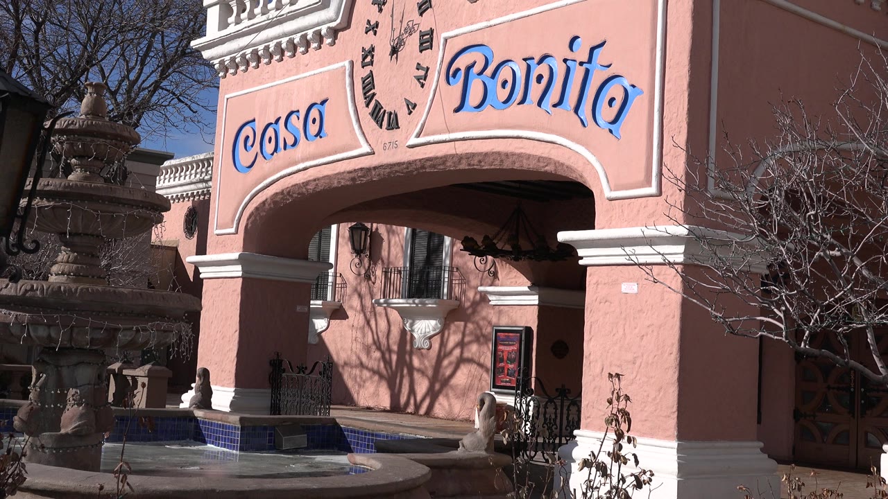 Pink stucco Casa Bonita facade with arched entrance and fountain