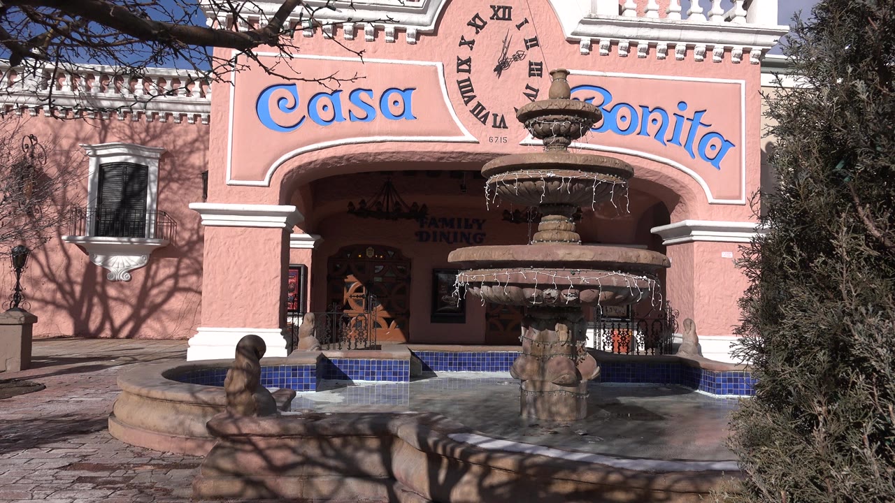 Pink Casa Bonita entrance with a tiered fountain in front.