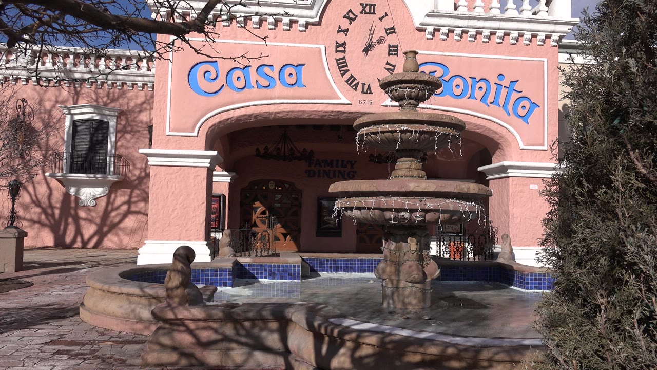 Second frame of the Denver exterior keeps the fountain slightly right of center with the Casa Bonita lettering above the arched doorway and no visible people.