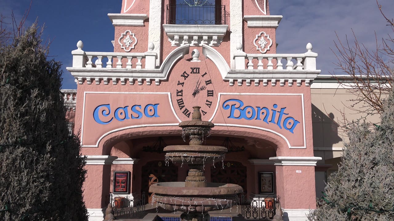Pink facade with Casa Bonita sign, fountain, and upper balcony.