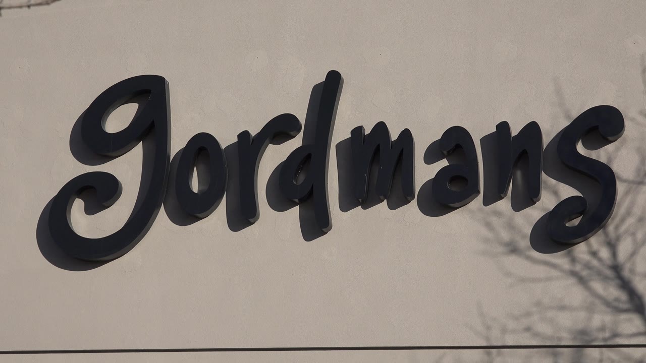 Jordmans sign on a pale facade with a thin roofline and tree shadows.