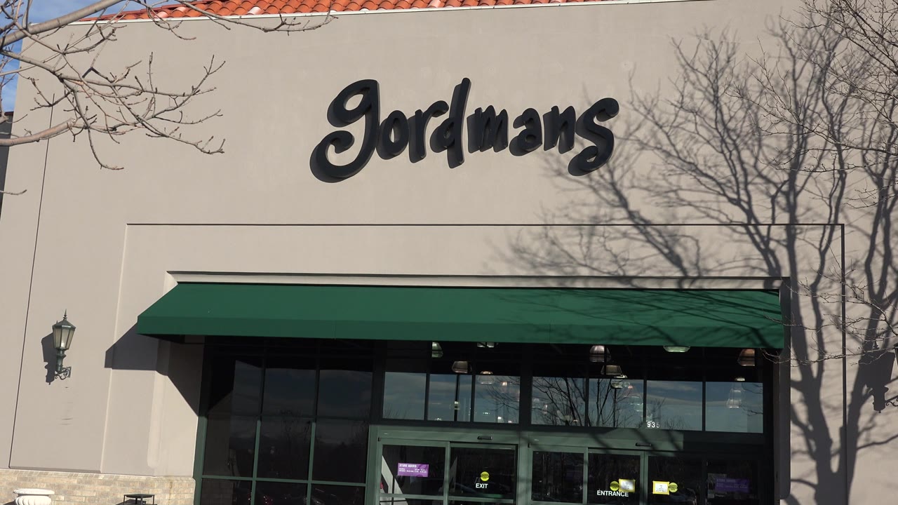 Gordmans storefront with green awning and tree shadows.