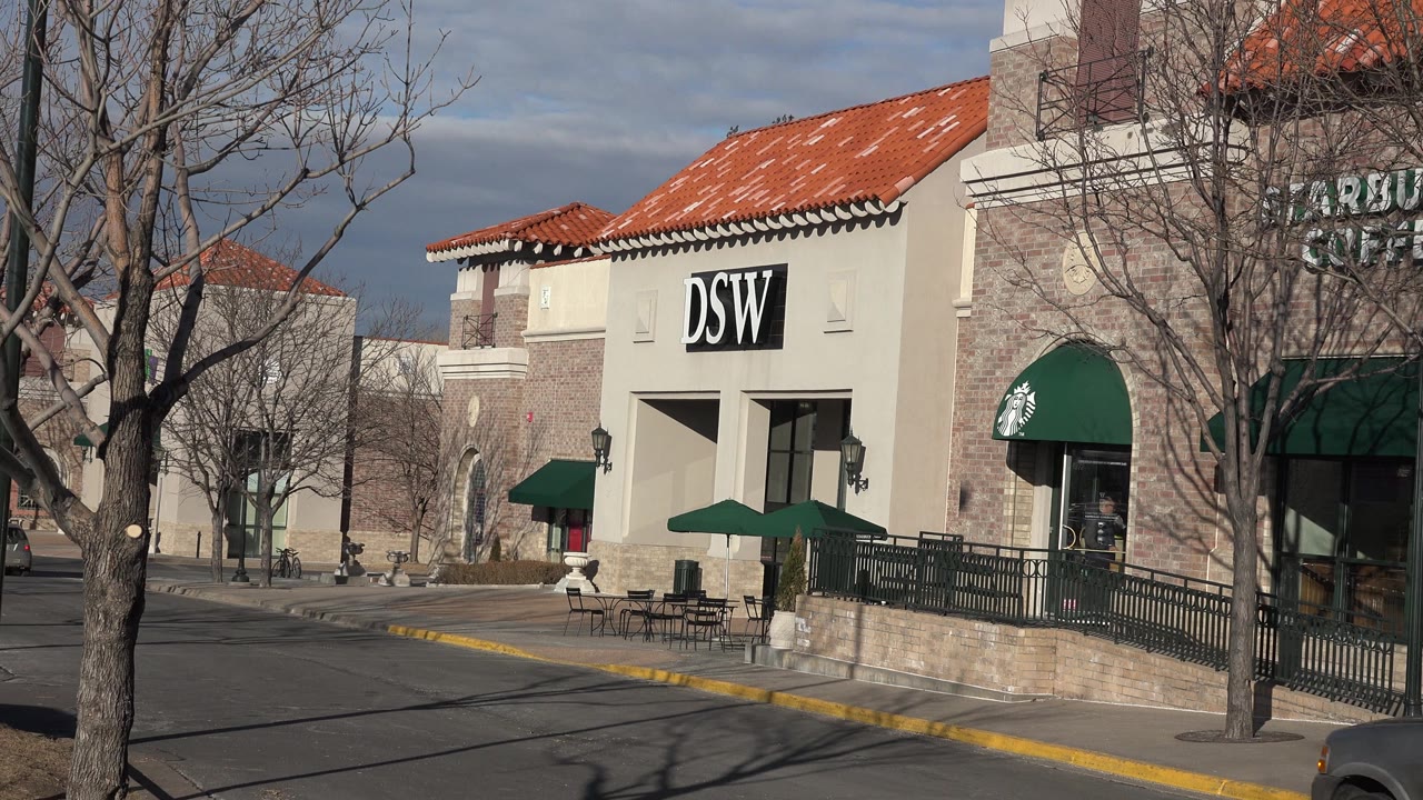 Shopping center exterior with Starbucks sign partly visible and DSW storefront.