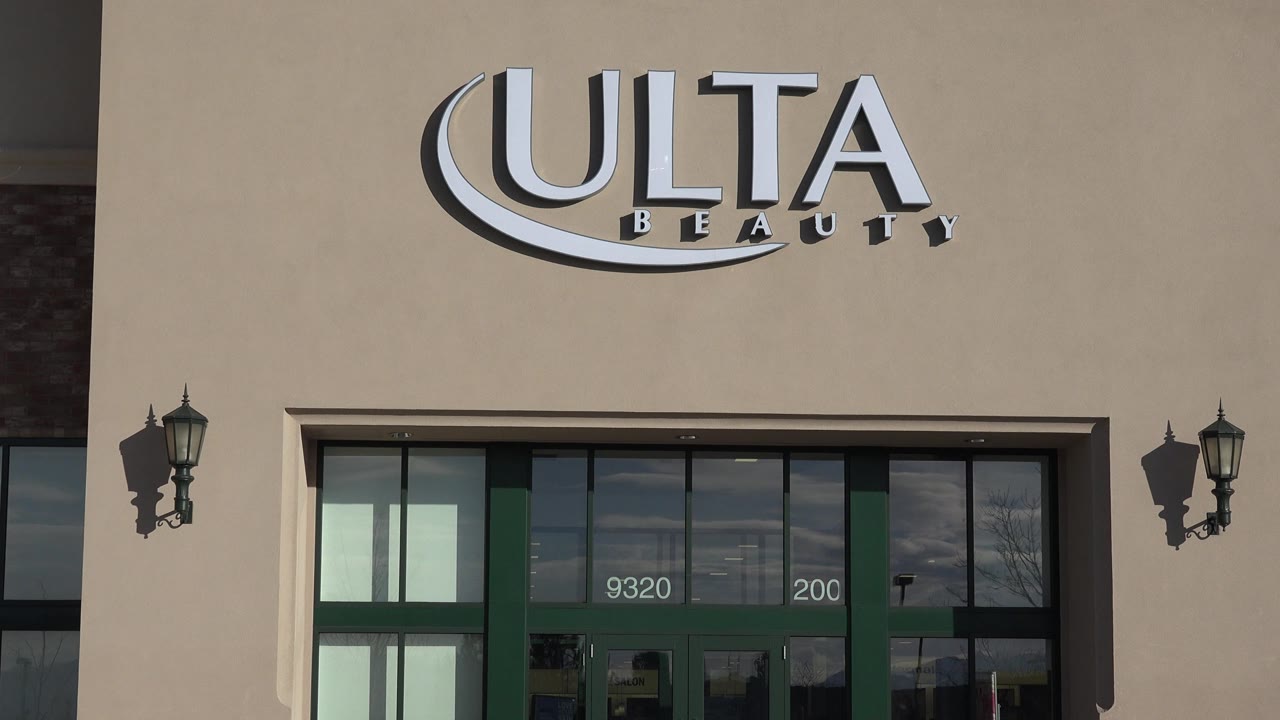 Denver retail facade with the Ulta Beauty sign centered high on the tan wall, entrance doors below, partial street address on the glass, and no visible people.
