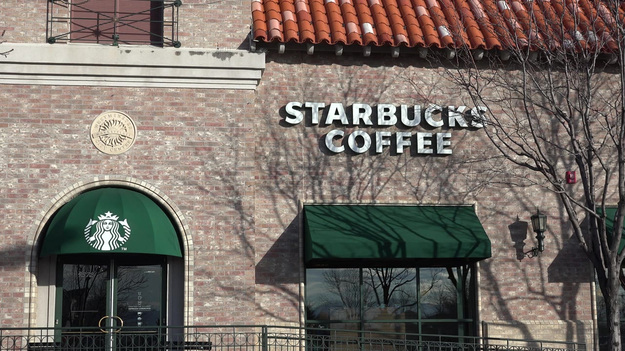 Starbucks Coffee sign on a brick storefront with green awnings.