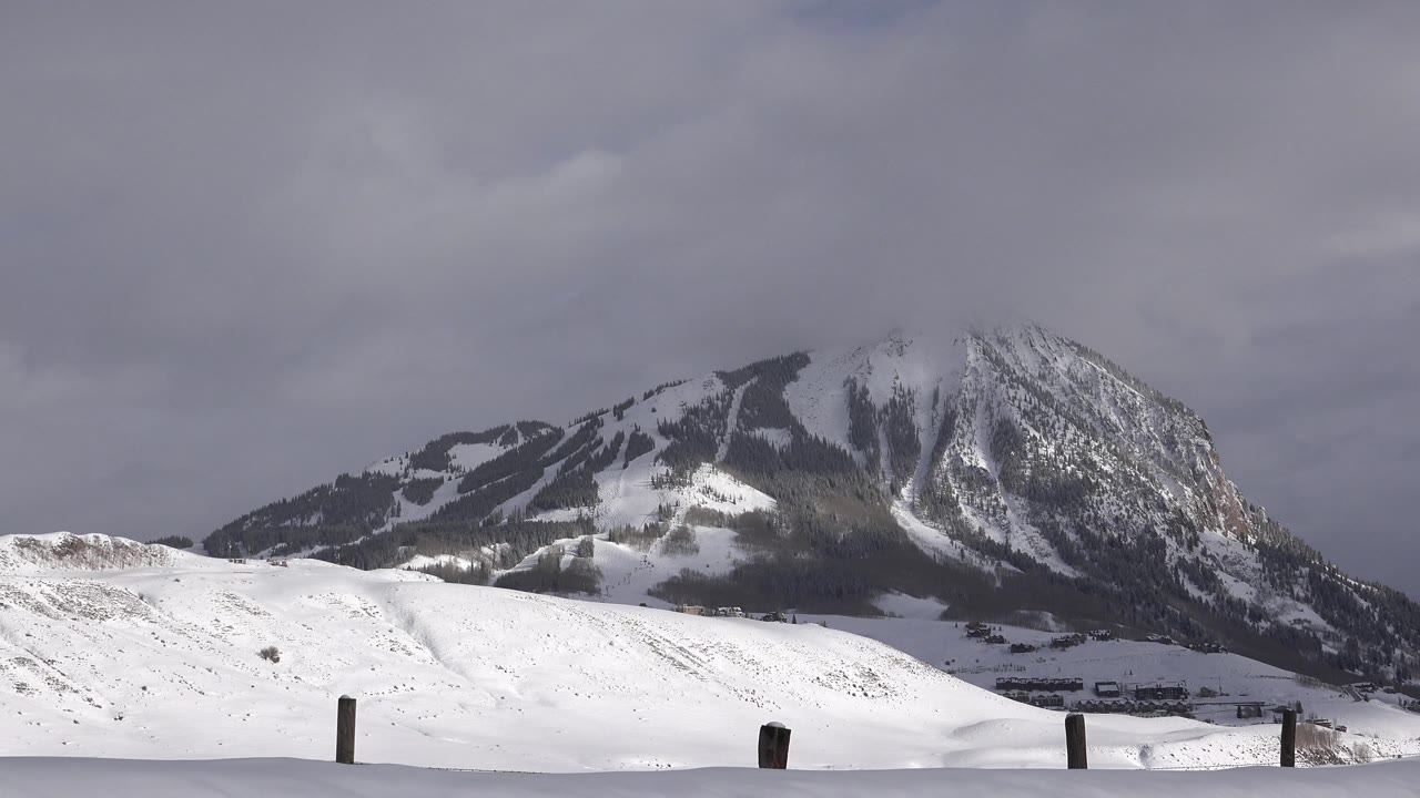 Snowy hills and mountain slopes beneath overcast winter clouds.