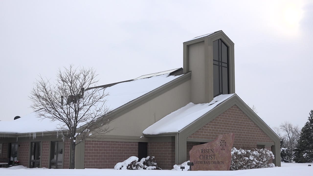 Snowy church roofline under pale winter sky