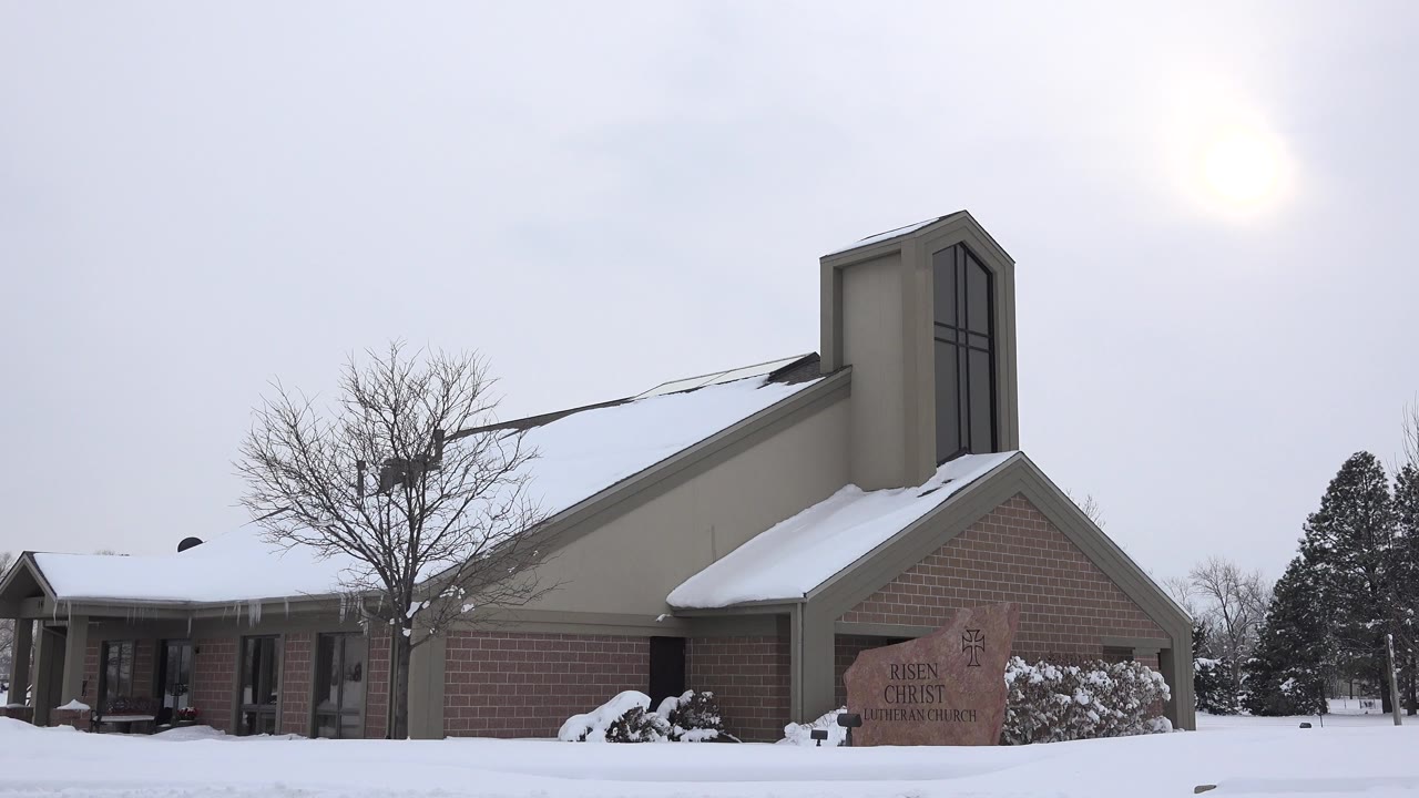 Snow-covered church exterior under hazy winter sun