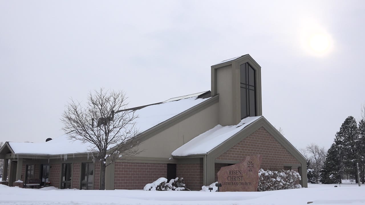 Snow-covered church exterior under a gray winter sky.