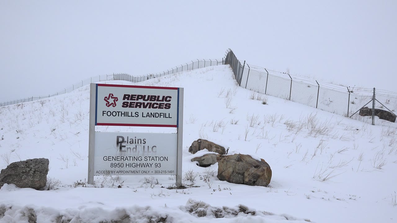 Republic Services Foothills Landfill sign in snow below a fenced berm.