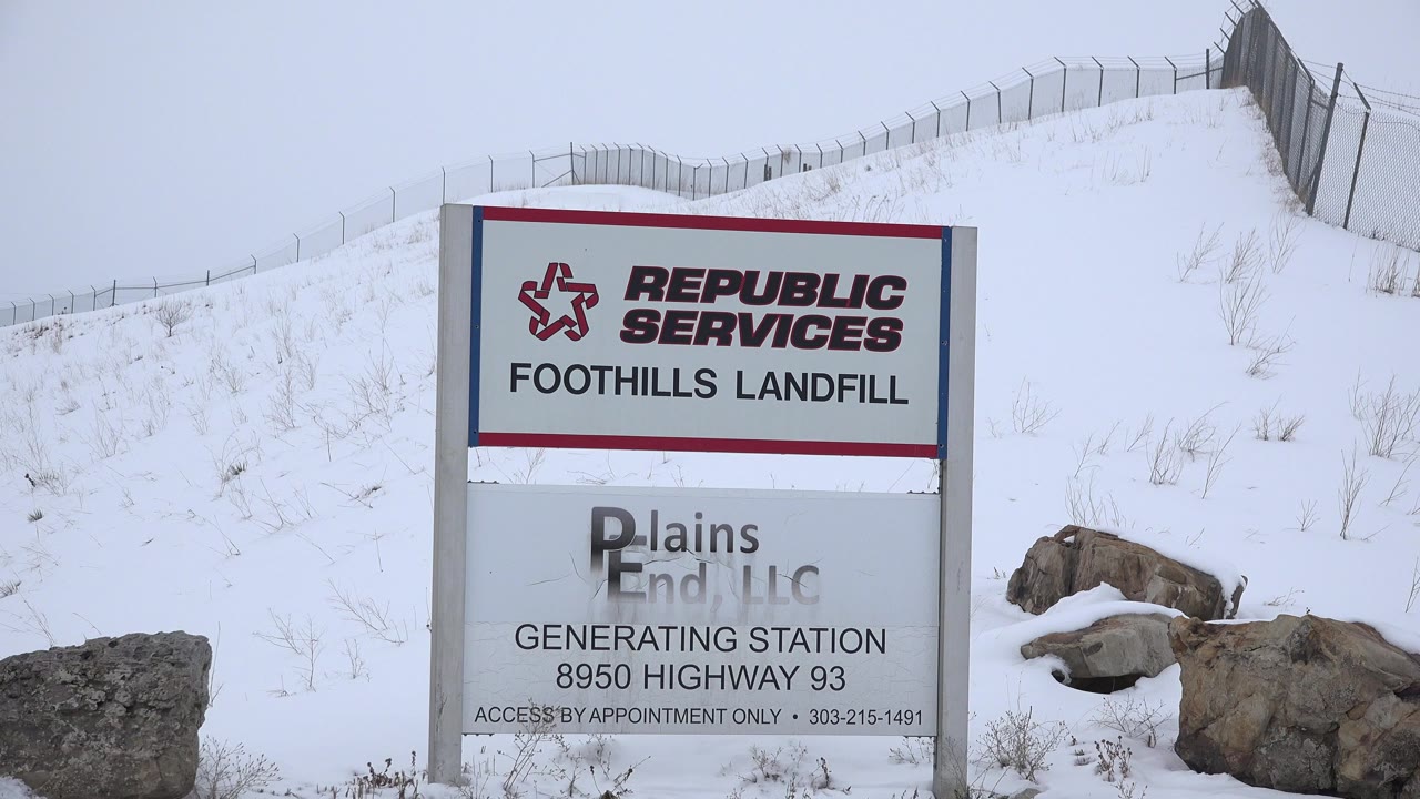 Republic Services landfill sign beside a snowy hill and fence.