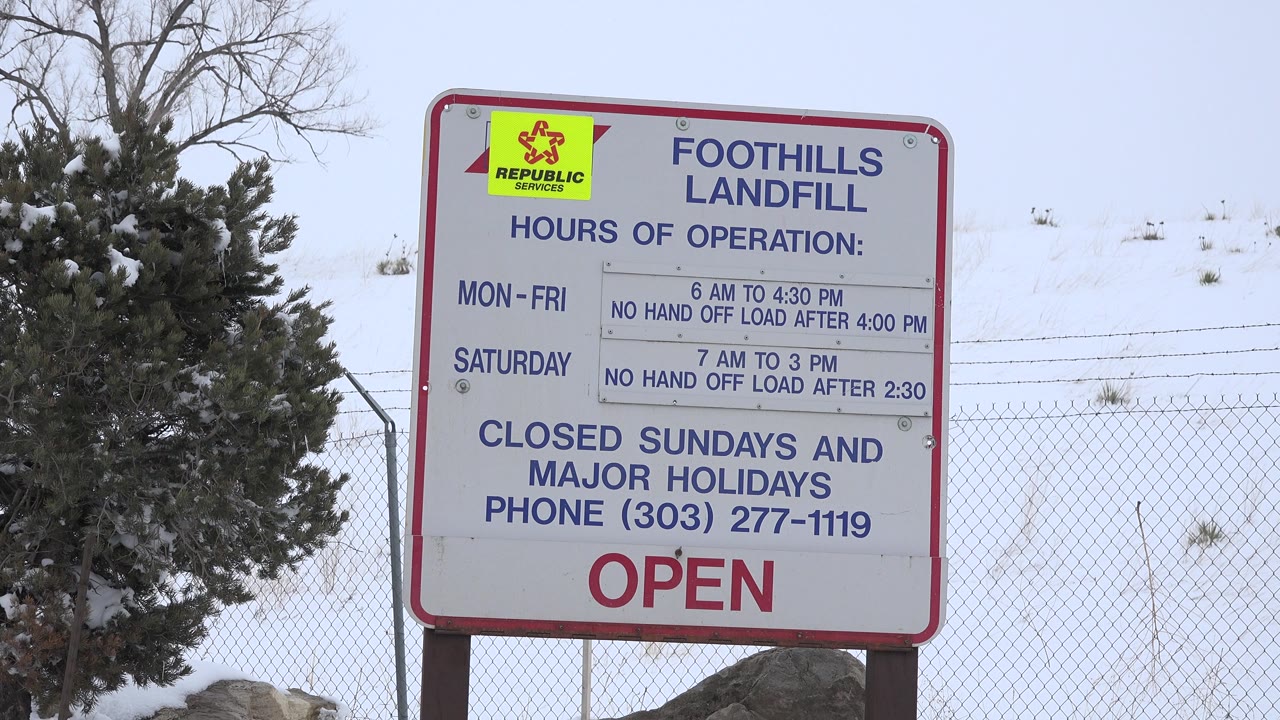 Foothills Landfill sign and fence under a pale sky.