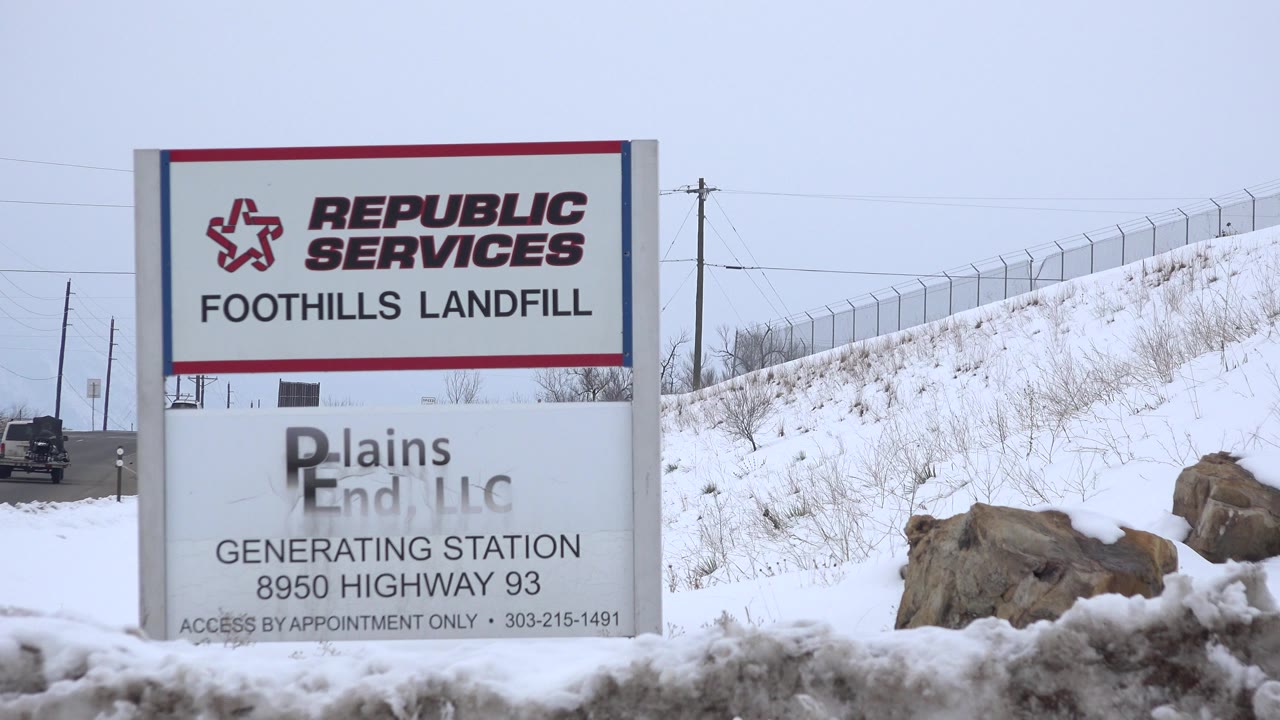 At 0:00, a Republic Services Foothills Landfill sign stands by a snowy roadside in Arvada, Colorado, with a fenced embankment and no visible people.