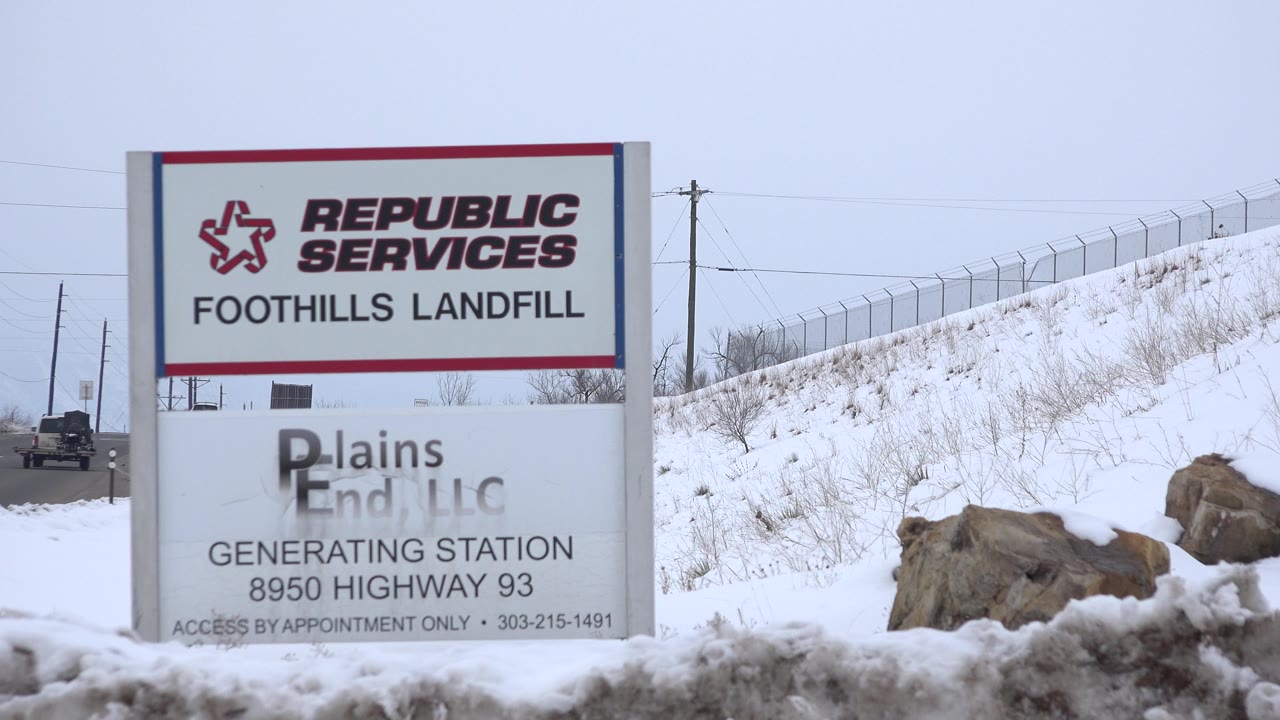 At 0:02, the Republic Services sign fills the left side while the snowy fenced embankment and road continue into the background, with no visible people.