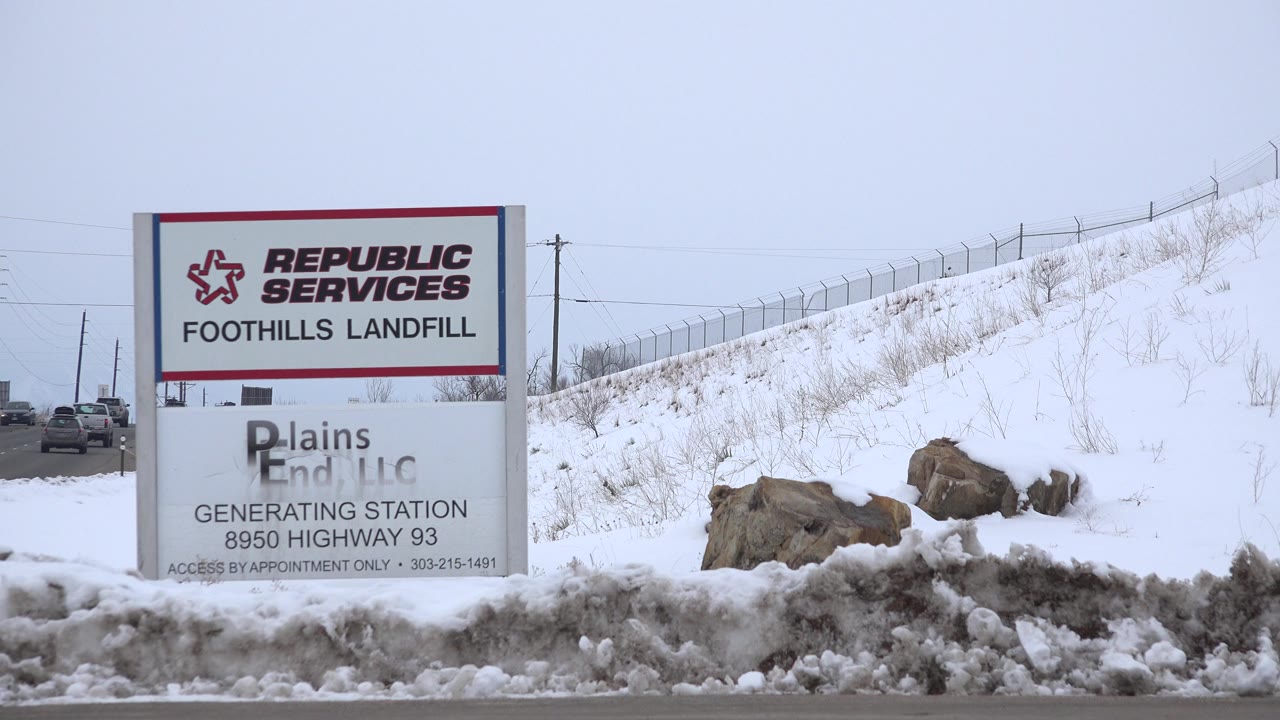Large landfill sign beside a snowy roadside embankment