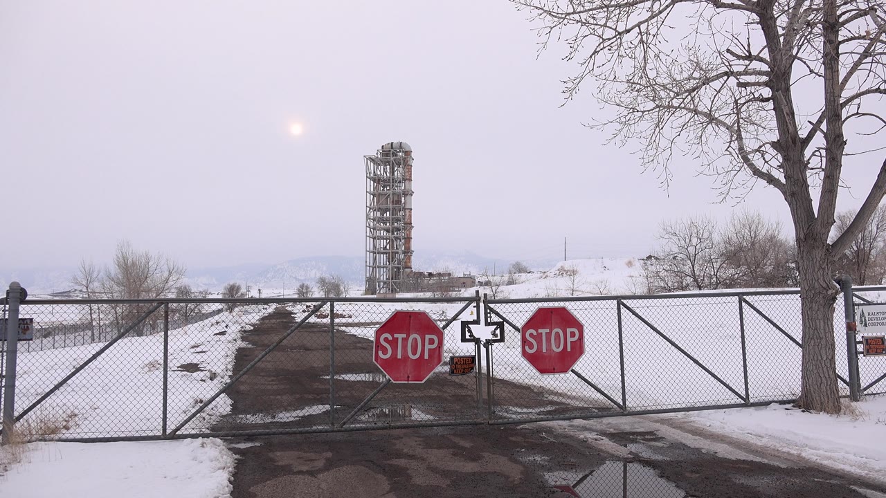 Stop signs on locked-looking gate in snowy open area