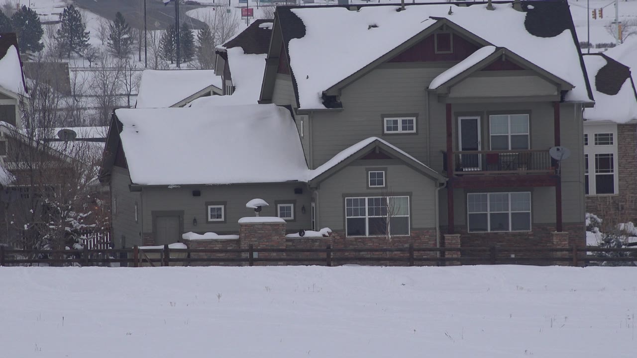 Snowy suburban house with field in foreground
