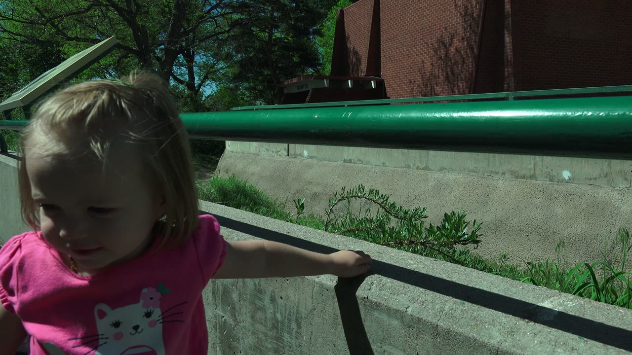 The child remains partly visible at the left side of the Westminster, Colorado frame, holding near a concrete wall with the green handrail running behind her.