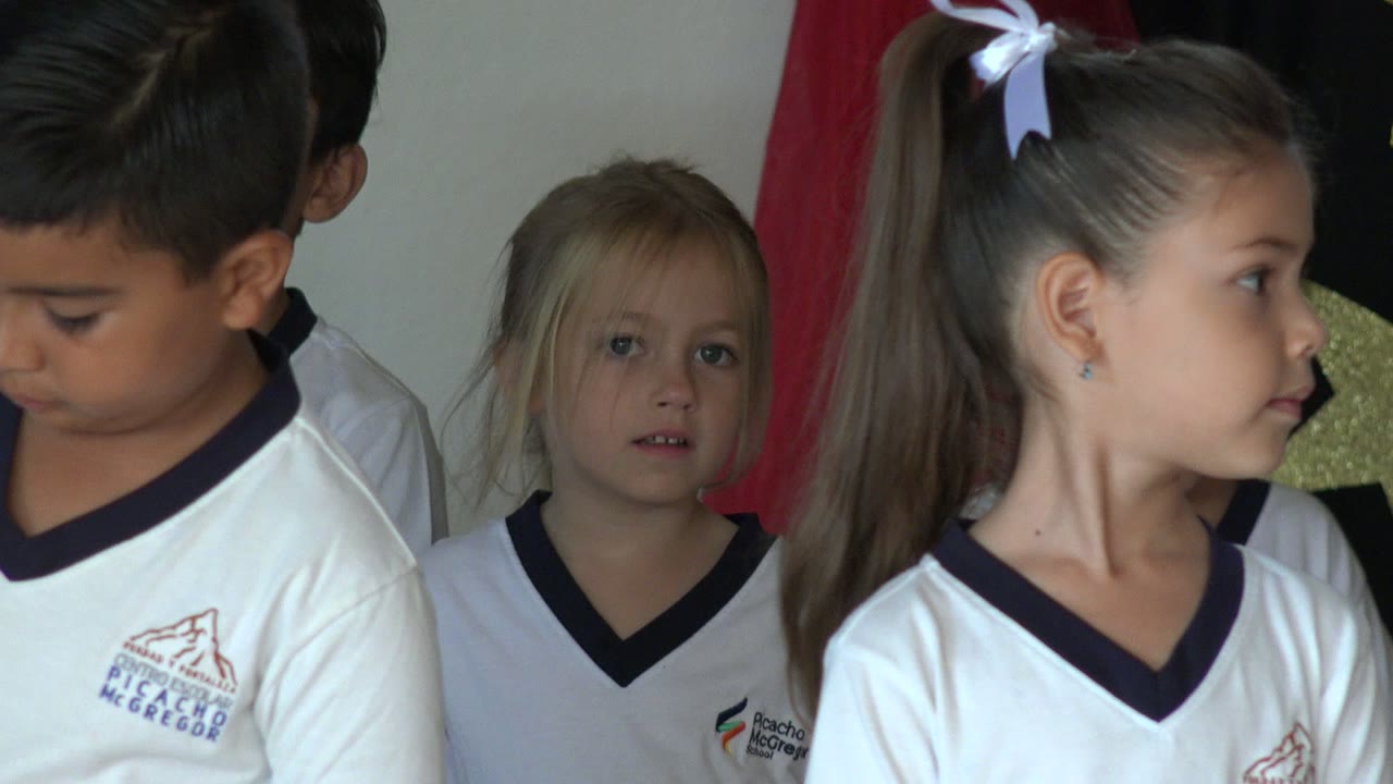 Girl with ponytail standing in front of other children.