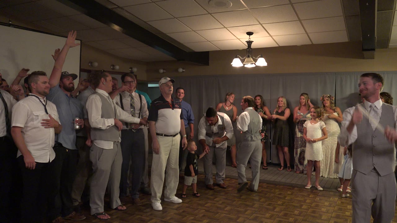 Guests cheering near a dance floor at a wedding reception.