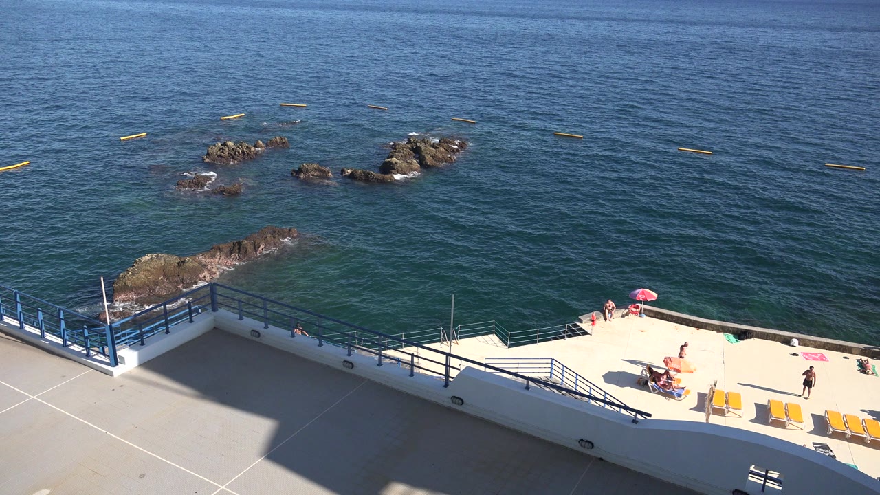 Seaside terrace above blue water and rocks