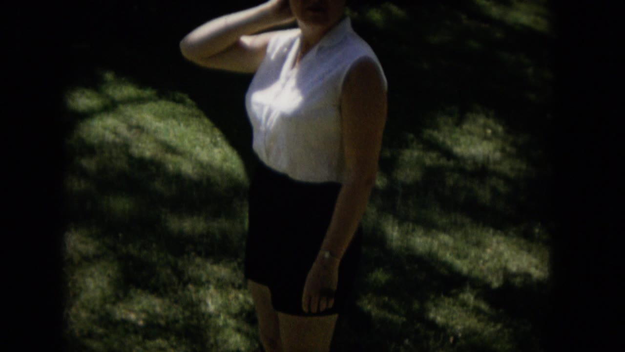 Woman partly cropped while standing on grass.
