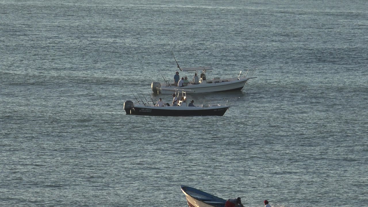 Grand Junction Colorado 2017 water view with two small boats near the top of frame and a low boat beside swimmers below them.