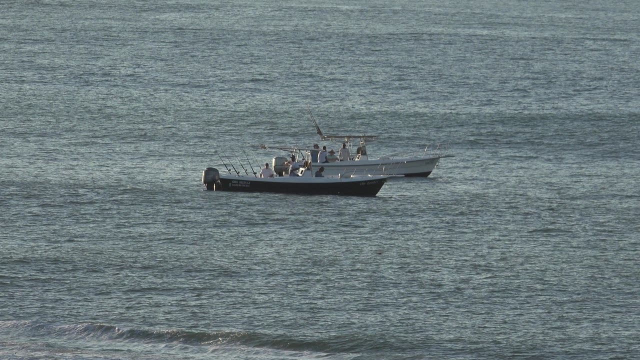 A small fishing boat remains centered on blue gray water in the Grand Junction, Colorado 2017 collection, with people visible near the console and rods standing at the stern.