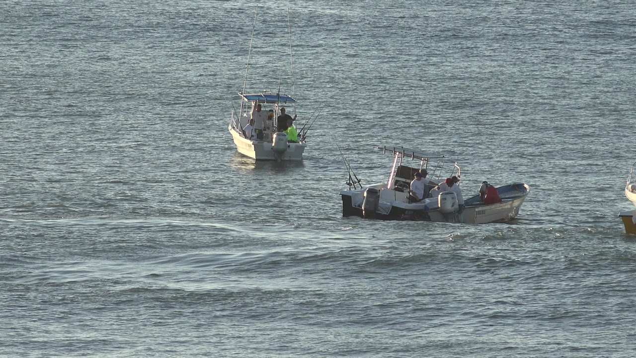 A later moment shows the same small fishing boats in Grand Junction, Colorado, slightly shifted across blue-gray water with rods and outboard motors visible.