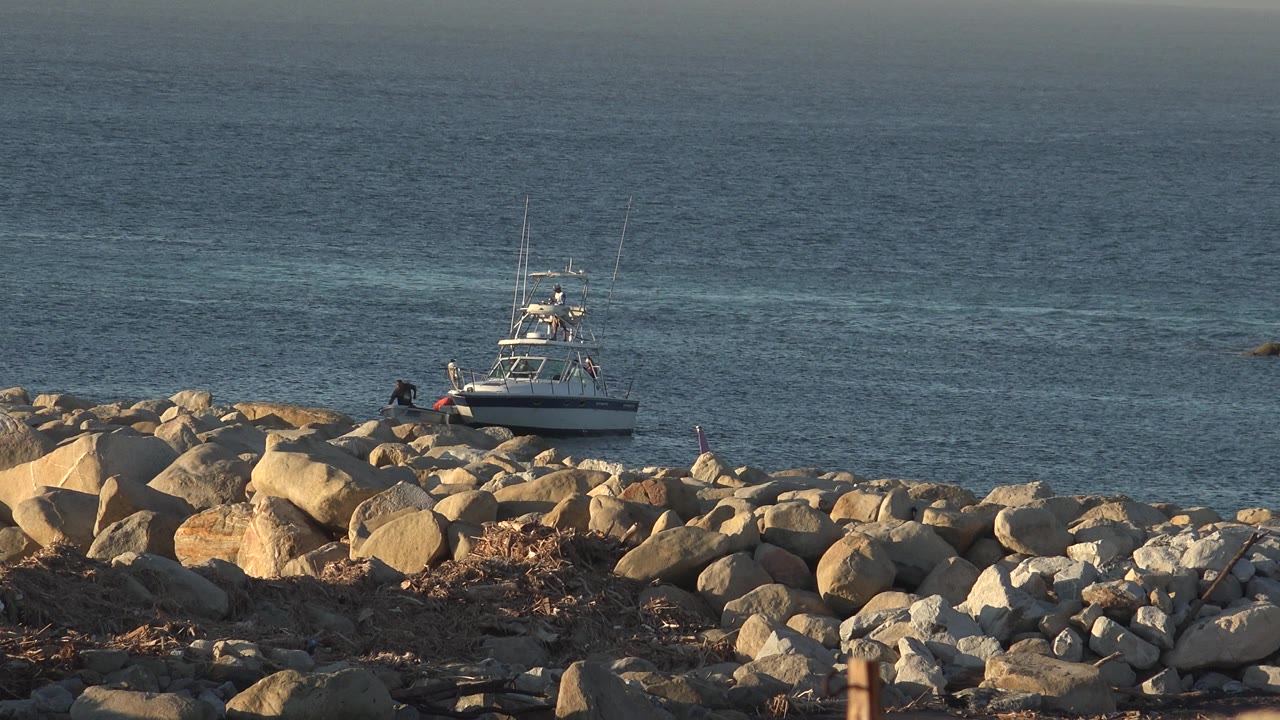 White boat and rocky shore under warm light.