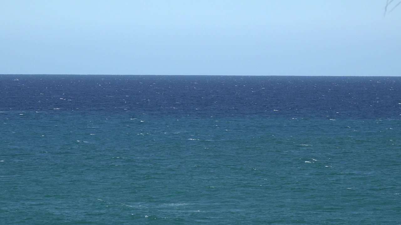 Blue ocean horizon beneath a pale sky.
