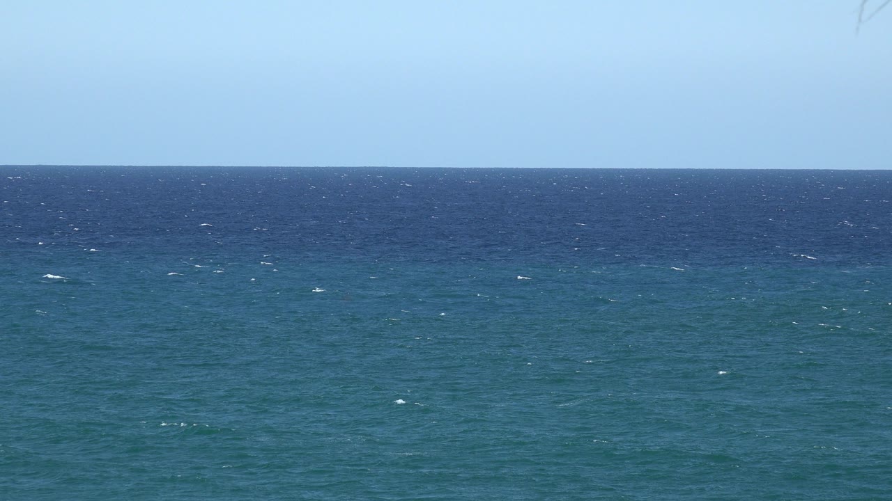 Open blue water sits below a pale sky in the Grand Junction Colorado 2017 clip, with scattered whitecaps shifting across the surface and no visible people.