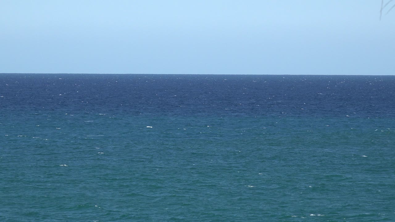 Opening frame of blue and teal water beneath a pale sky in Grand Junction, Colorado, with scattered whitecaps and no visible people.